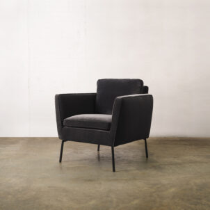 Black velvet armchair with high armrests and black metal legs